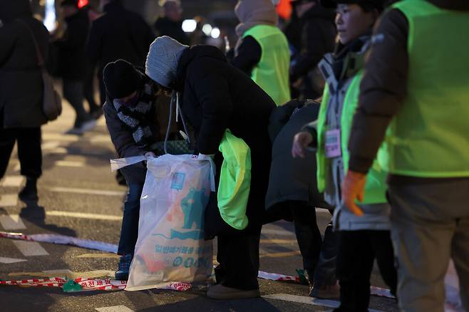 범시민총궐기대회가 열린 11일 저녁 시민들이 서울 종로구 광화문 동십자각 일대에서 명동 방향으로 행진을 시작하자 주최쪽 관계자들이 쓰레기를 치우고 있다. 김영원 기자 forever@hani.co.kr