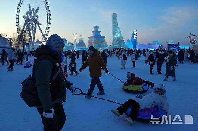 [하얼빈=AP/뉴시스] 6일 중국 헤이룽장성 하얼빈에서 열린 제41회 하얼빈 빙설제에서 관광객들이 썰매를 타고 있다. 2025.01.10.