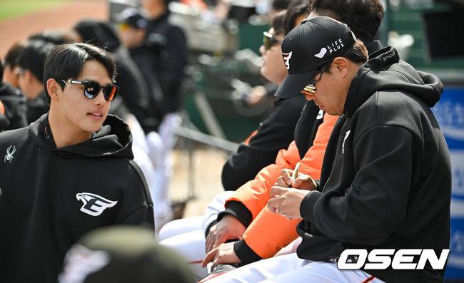 [OSEN=박준형 기자] 한화 류현진이 황준서의 프로 첫 삼진 기념구에 글을 쓰고 있다.  2024.03.31 / soul1014@osen.co.kr