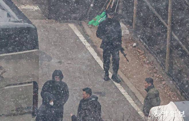 K2C1 소총을 든 한 경호병력이 13일 서울 용산구 한남동 대통령 관저 외곽에서 버스벽을 세우고 있는 경호처 직원들 옆을 지나고 있다. 박형기 기자 oneshot@donga.com