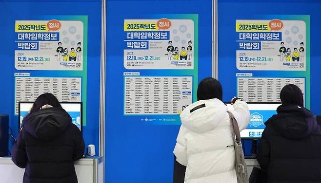 지난 2024년 12월 서울 강남구 코엑스에서 열린 2025학년도 정시 대학입학정보박람회를 찾은 수험생들이 안내문을 살펴보고 있다. 연합뉴스