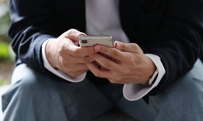 한 시민이 핸드폰을 보고 있다. 사진은 기사 내용과 직접적 관련 없음. 연합뉴스