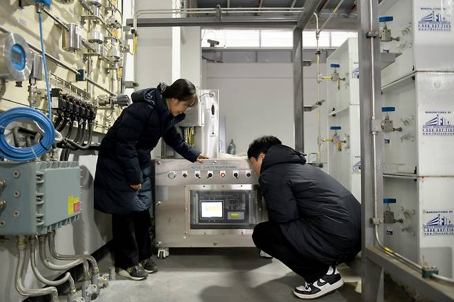 한국표준과학연구원의 이정순(왼쪽) 책임연구원과 김상우 박사후연구원이 충주시 수소 버스충전소에 설치된 모니터링 장비를 점검하고 있다./한국표준과학연구원