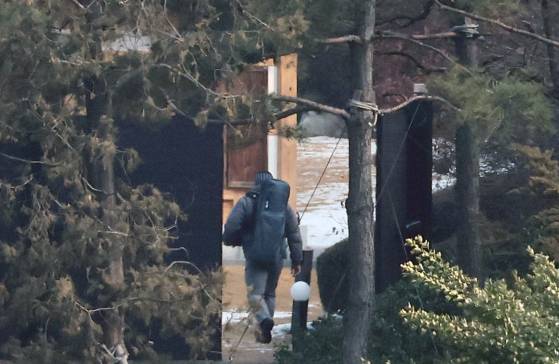 공수처와 경찰의 윤석열 대통령 2차 체포영장 집행 시도가 임박한 가운데 14일 서울 용산구 한남동 대통령 관저에서 소총 가방으로 추정되는 배낭을 멘 경호처 요원이 이동하고 있다. 뉴스1