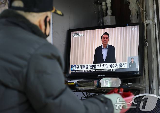 고위공직자범죄수사처와 경찰로 구성된 공조수사본부가 윤석열 대통령에 대한 2차 체포영장 집행한 15일 오후 서울 시내 전통시장에서 한 상인이 윤석열 대통령 체포 관련 뉴스를 시청하고 있다. 2025.1.15/뉴스1 ⓒ News1 임세영 기자