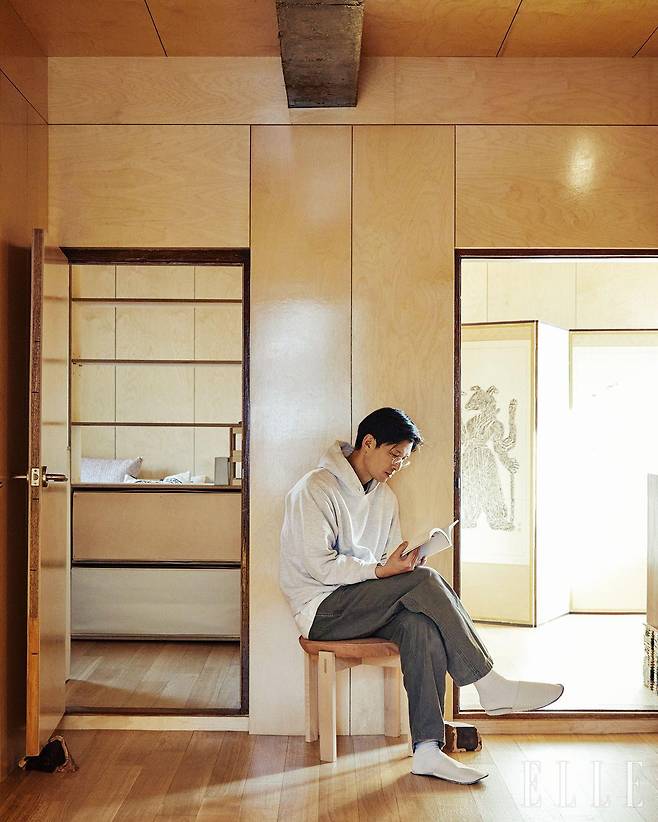 거실에 앉아 있는 박찬용. 천장의 보와 문턱, 야트막한 문높이, 낡은 문틀은 기존 것을 그대로 남긴 것이다.