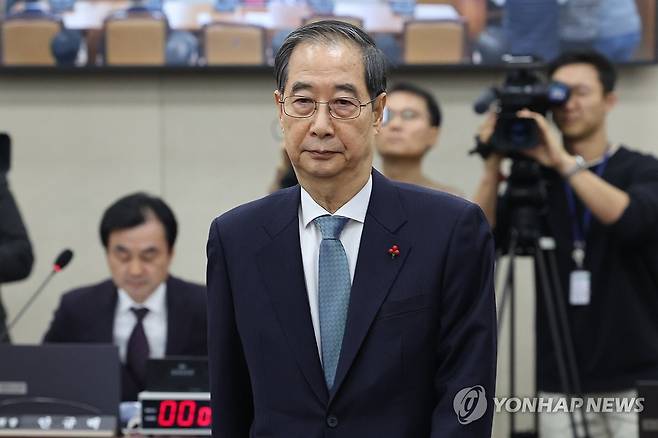 '내란 국조특위' 출석한 한덕수 총리 (서울=연합뉴스) 김주성 기자 = 한덕수 국무총리가 15일 국회 '윤석열 정부의 비상계엄 선포를 통한 내란혐의 진상규명 국정조사' 특별위원회에 기관 증인으로 출석해 안규백 위원장에게 선서문을 전달한 뒤 자리로 돌아가고 있다. 2025.1.15 utzza@yna.co.kr