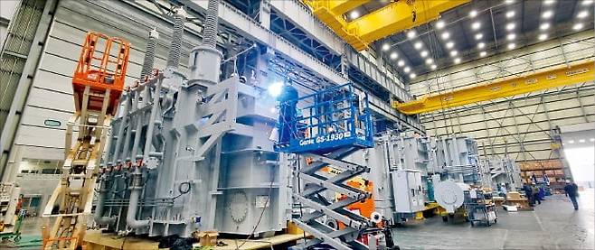 < 5년치 일감 쌓인 HD현대일렉트릭 >  지난 13일 미국 앨라배마주에 있는 HD현대일렉트릭 몽고메리 공장에서 한 직원이 초고압 변압기 외부에 방열기를 부착하는 용접 작업을 하고 있다.  /몽고메리=김진원 기자