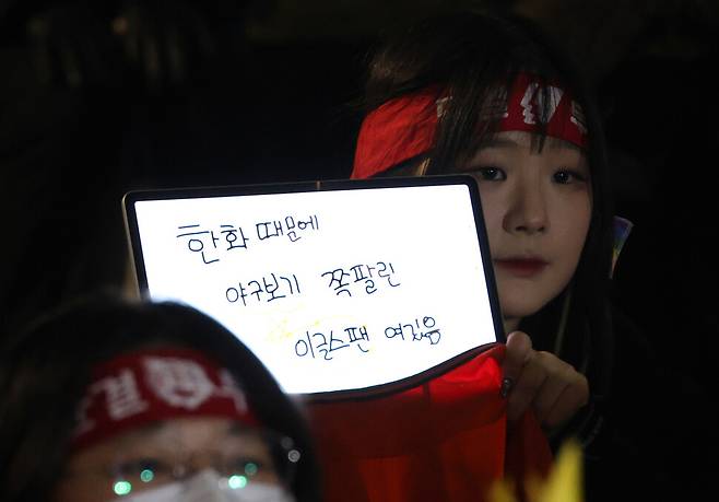 문화제 참석자가 한화를 규탄하는 글귀를 태블릿에 띄우고 있다.