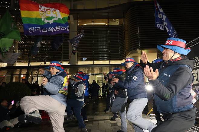 무지갯빛 금속노조 깃발 아래서 조선하청지회 조합원들이 춤추고 있다.