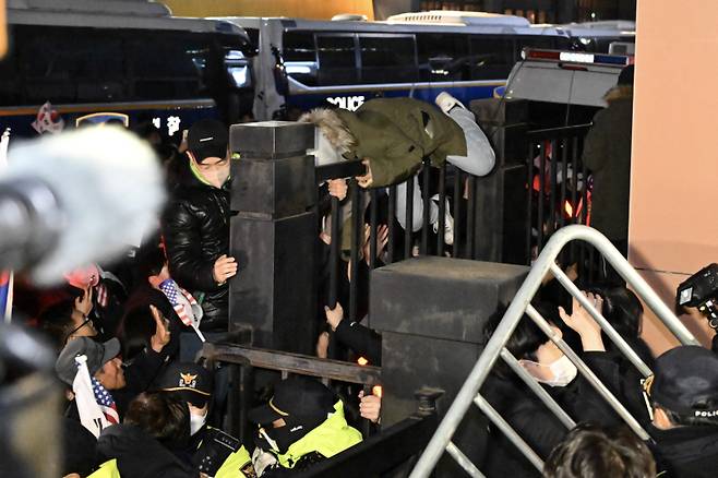 내란 우두머리 혐의를 받는 윤석열 대통령이 구속된 가운데 19일 서울 마포구 서울서부지법에서 윤 대통령 지지자들이 법원 담장을 넘으려 시도하고 있다. 연합뉴스&nbsp;