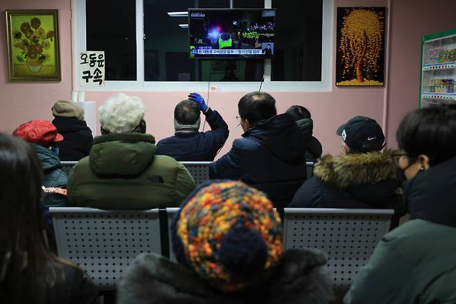 내란 우두머리 혐의를 받는 윤석열 대통령이 구속된 19일 오전 경기 의왕시 서울구치소 민원인 쉼터에서 윤 대통령 지지자들이 관련 보도를 보고 있다. 연합뉴스&nbsp;