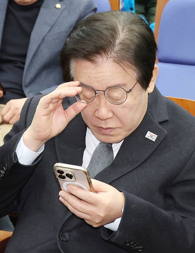 이재명 더불어민주당 대표가 지난 19일 국회에서 열린 비상의원총회에 입장해 휴대폰을 살펴보고 있다. [연합]