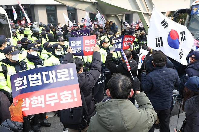 윤석열 대통령의 탄핵심판 3차 변론이 열리는 21일 서울 종로구 헌법재판소 인근에서 윤 대통령 지지자들이 집회를 열고 탄핵 무효를 주장하는 구호를 외치고 있다.  연합뉴스