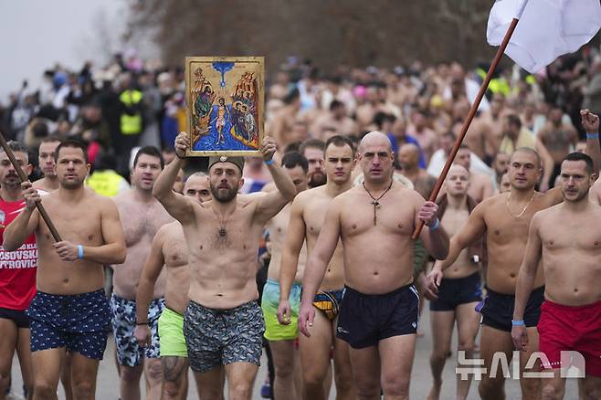 [베오그라드=AP/뉴시스] 19일(현지 시간) 세르비아 베오그라드에서 주현절 기념행사가 열려 정교회 신자들이 십자가를 찾기 위해 다뉴브강에 뛰어 들기 위해 이동하고 있다. 이날 동방 정교회 사제가 물에 던진 나무 십자가를 찾아오는 사람뿐 아니라 이를 찾기 위해 물에 뛰어든 사람 모두가 일 년 내내 건강하게 지낼 수 있다고 믿는다. 2025.01.20.