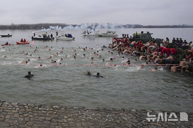 [베오그라드=AP/뉴시스] 19일(현지 시간) 세르비아 베오그라드에서 주현절 기념행사가 열려 정교회 신자들이 십자가를 찾기 위해 다뉴브강에 뛰어 들고 있다. 이날 동방 정교회 사제가 물에 던진 나무 십자가를 찾아오는 사람뿐 아니라 이를 찾기 위해 물에 뛰어든 사람 모두가 일 년 내내 건강하게 지낼 수 있다고 믿는다. 2025.01.20.