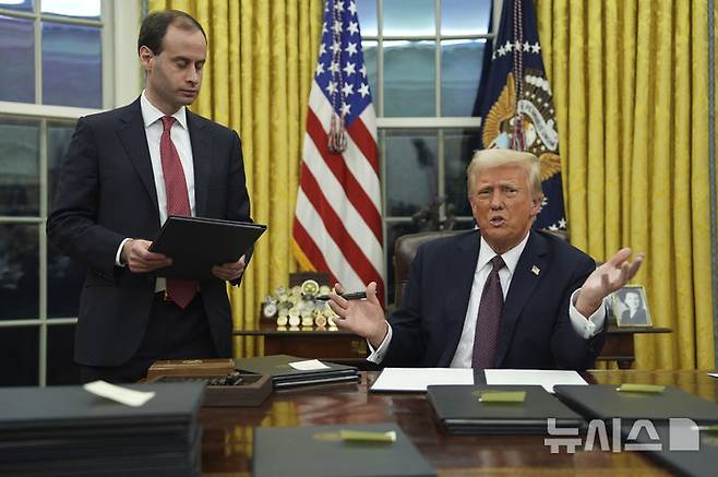 [워싱턴=AP/뉴시스]도널드 트럼프 미국 대통령이 20일(현지 시간) 백악관 입성 후 오벌오피스에서 각종 행정명령에 서명하고 있다. 2025.01.21.