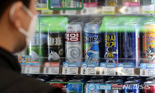 [서울=뉴시스] 백동현 기자 = CU가 수제맥주를 중심으로 대대적인 프로모션을 진행하고 있는 28일 오전 서울 시내 한 CU 편의점에서 한 시민이 수제맥주를 살펴보고 있다. 전날 CU 관계자에 따르면 CU는 올해 수입맥주를 필두로 한 맥주 가격 인상에도 불구하고 수제맥주 6캔 9900원 등의 파격 행사를 진행해 매출 상승효과를 보고 있다고 밝혔다. 2022.03.28. livertrent@newsis.com