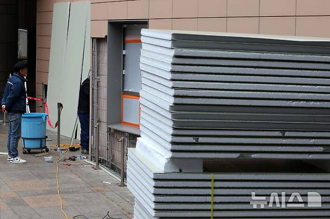 [서울=뉴시스] 이영환 기자 = 20일 오전 서울 마포구 서울서부지방법원에서 공사 관계자들이 파손된 외벽에 보수작업을 하고 있다.지난 19일 새벽 윤석열 대통령의 구속영장 발부에 지지자들이 집단 폭력 및 법원 안으로 침입하는 사고가 발생했다. 한편 서울서부지방법원은 법원은 정상적으로 운영될 것이라고 밝혔다. 다만 차량을 통한 출입은 불가능하고 출입자는 신분 확인이 필요하다고 전했다.  2025.01.20. 20hwan@newsis.com