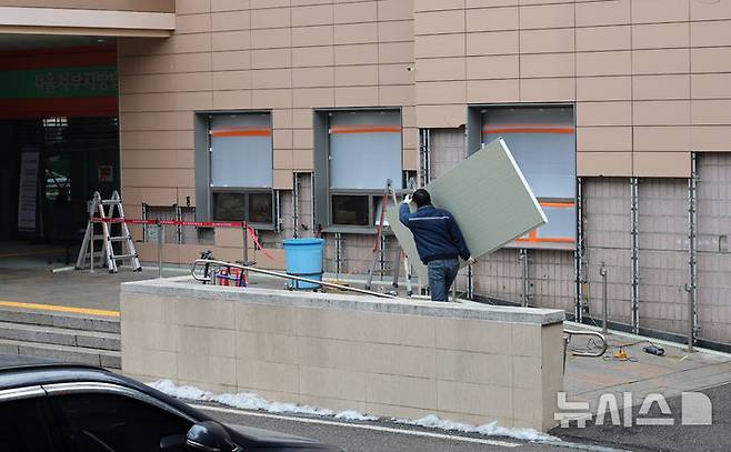 [서울=뉴시스] 이영환 기자 = 20일 오전 서울 마포구 서울서부지방법원에서 공사 관계자들이 파손된 외벽에 보수작업을 하고 있다. 지난 19일 새벽 윤석열 대통령의 구속영장 발부에 지지자들이 집단 폭력 및 법원 안으로 침입하는 사고가 발생했다. 한편 서울서부지방법원은 법원은 정상적으로 운영될 것이라고 밝혔다. 다만 차량을 통한 출입은 불가능하고 출입자는 신분 확인이 필요하다고 전했다.  2025.01.20. 20hwan@newsis.com