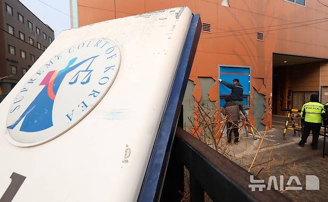 [서울=뉴시스] 이영환 기자 = 20일 오전 서울 마포구 서울서부지방법원에서 공사 관계자들이 파손된 외벽 및 창문 보수작업을 하고 있다. 지난 19일 새벽 윤석열 대통령의 구속영장 발부에 지지자들이 집단 폭력 및 법원 안으로 침입하는 사고가 발생했다. 한편 서울서부지방법원은 법원은 정상적으로 운영될 것이라고 밝혔다. 다만 차량을 통한 출입은 불가능하고 출입자는 신분 확인이 필요하다고 전했다.  2025.01.20. 20hwan@newsis.com