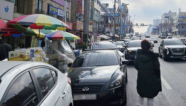 22일 오후 인천 남동구 모래내·구월시장 옆 도로, 주차할 곳이 없어 한 시민이 도로 한복판으로 나와 일행의 차량을 기다리고 있다. 장민재기자