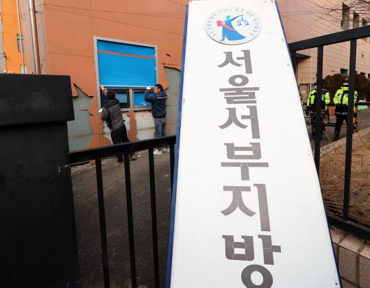 지난 20일 오전 서울 마포구 서울서부지방법원에서 공사 관계자들이 파손된 외벽 및 창문 보수작업을 하고 있다. 뉴시스
