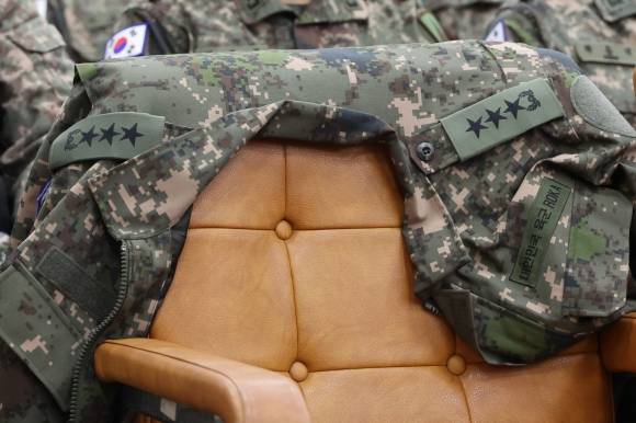 국정조사 특위 증인석에 걸린 별 달린 군복 - 14일 서울 여의도 국회에서 열린 ‘윤석열 정부의 비상계엄 선포를 통한 내란 혐의 진상규명 국정조사 특별위원회의. 기관 증인으로 출석한 이진우 국군 수도방위사령관이 벗어둔 군복이 증인석에 걸려 있다. 2025.1.14 연합뉴스