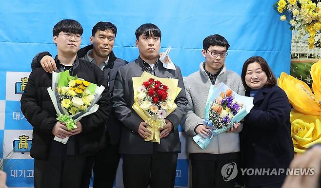 고교 졸업한 세쌍둥이와 부모 (제주=연합뉴스) 김호천 기자 = 23일 제주시에 있는 대기고등학교를 졸업한 세쌍둥이 박찬승(가운데)·찬영(왼쪽)·찬호 군과 아버지 박영호 씨, 어머니 김숙희 씨. 2025.1.23 khc@yna.co.kr