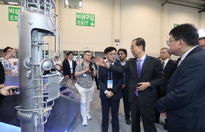 한덕수 국무총리(오른쪽 두번째)가 작년 9월 부산 해운대구 제1전시장에서 열린 '2024 기후산업국제박람회'에서 두산에너빌리티 부스를 찾아 소형모듈원자로(SMR) 모형을 둘러보고 있다. 뉴스1