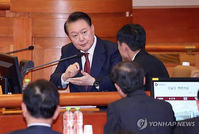 지난 23일 윤석열 대통령이 헌법재판소에서 열린 탄핵심판 4차 변론에 출석해 변호인단과 대화하고 있다.ⓒ연합뉴스
