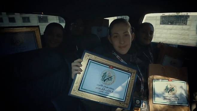 이스라엘 인질이 지난 25일 석방에 앞서 하마스가 발행한 인질 증명서와 선물 봉투를 보여주고 있다.