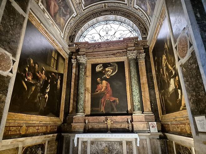 카라바조의 마태 3부작. 왼쪽이 [마태의 소명]이다. 동전을 넣으면 조명이 켜진다. ⓒ김슬기