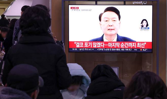 윤석열 대통령의 탄핵소추안이 국회에서 가결된 지난해 12월14일 오후 서울역에서 시민들이 윤석열 대통령의 대국민 담화를 TV를 통해 지켜보고 있다. ⓒ연합뉴스