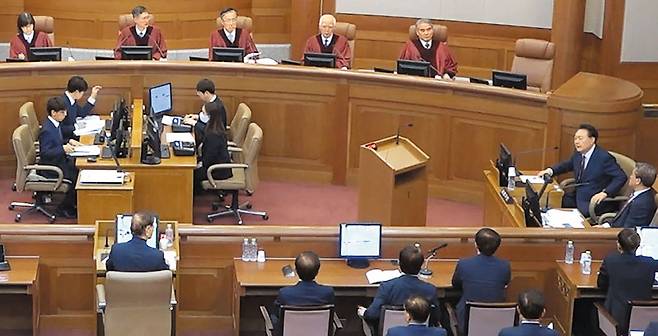 지난 23일 오후 서울 종로구 헌법재판소에서 열린 윤석열 대통령 탄핵심판 공개 변론. 윤 대통령(사진 맨 오른쪽)이 김용현(맨 왼쪽 아래) 전 국방부장관에게 질문하고 있다. 헌법재판관들이 이를 듣고 있다. /헌법재판소