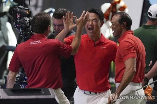 우즈(오른쪽)와 함께 승리를 기뻐하는 김주형(가운데)