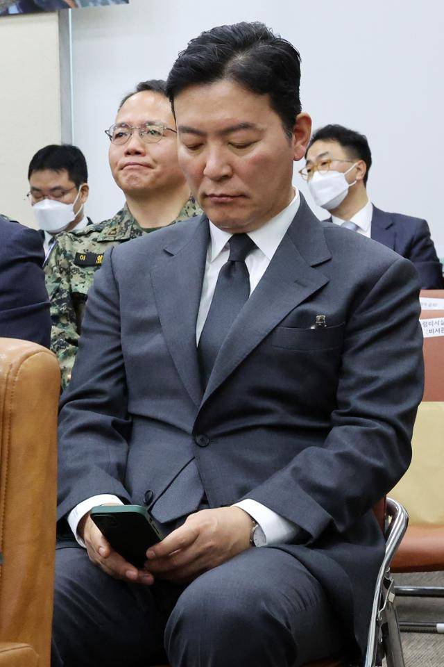 김성훈 대통령경호처 차장이 22일 국회에서 열린 윤석열 정부의 비상계엄 선포를 통한 내란 혐의 진상규명 국정조사 특별위원회 1차 청문회에 출석해 휴대전화를 보고 있다. 뉴시스