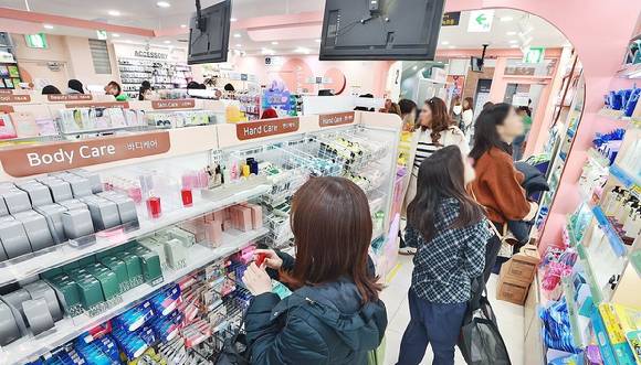 소비자들이 서울 중구 다이소 명동역점에 진열된 소용량 화장품을 둘러보고 있다.  [사진=연합뉴스]