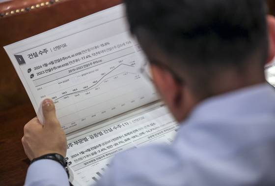 지난해 열린 건설, 부동산 경기 전망 세미나에서 힌 참석자가 자료집을 살펴보고 있다. 뉴시스