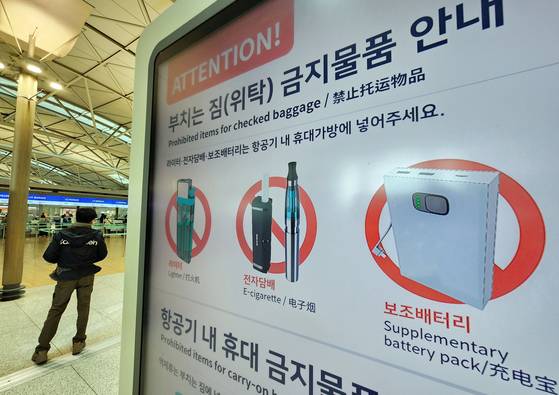 A notice at Incheon International Airport displays prohibited items for checked baggage, including portable batteries, on Jan. 30. [YONHAP]