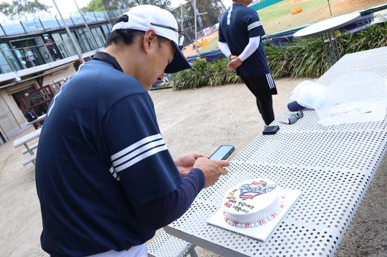두산의 선전을 기원하는 떡케이크를 휴대폰 카메라로 찍는 이승엽 감독. 사진 두산 베어스