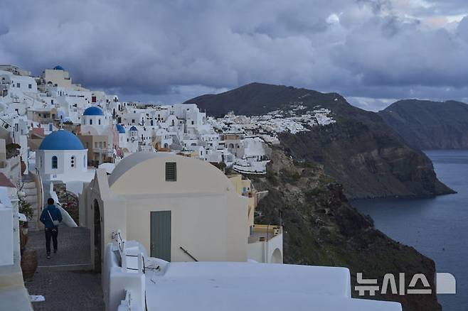 [산토리니=AP/뉴시스] 4일(현지 시간) 그리스 산토리니 섬에서 관광객이 이동하고 있다. 최근 산토리니섬과 주변 섬에서 무려 6400회 이상의 지진이 발생하면서 주민과 관광객들이 공포 속에 섬을 떠나고 있다. 2025.02.06.