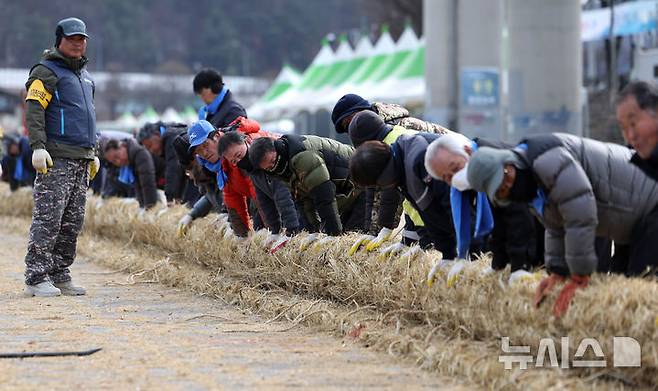 [청도=뉴시스] 이무열 기자 = 6일 오후 경북 청도군 청도천 둔치에서 군민들이 ‘2025 정월대보름 민속한마당’에 사용될 도주줄당기기 가닥줄을 엮고 있다. 2025.02.06. lmy@newsis.com