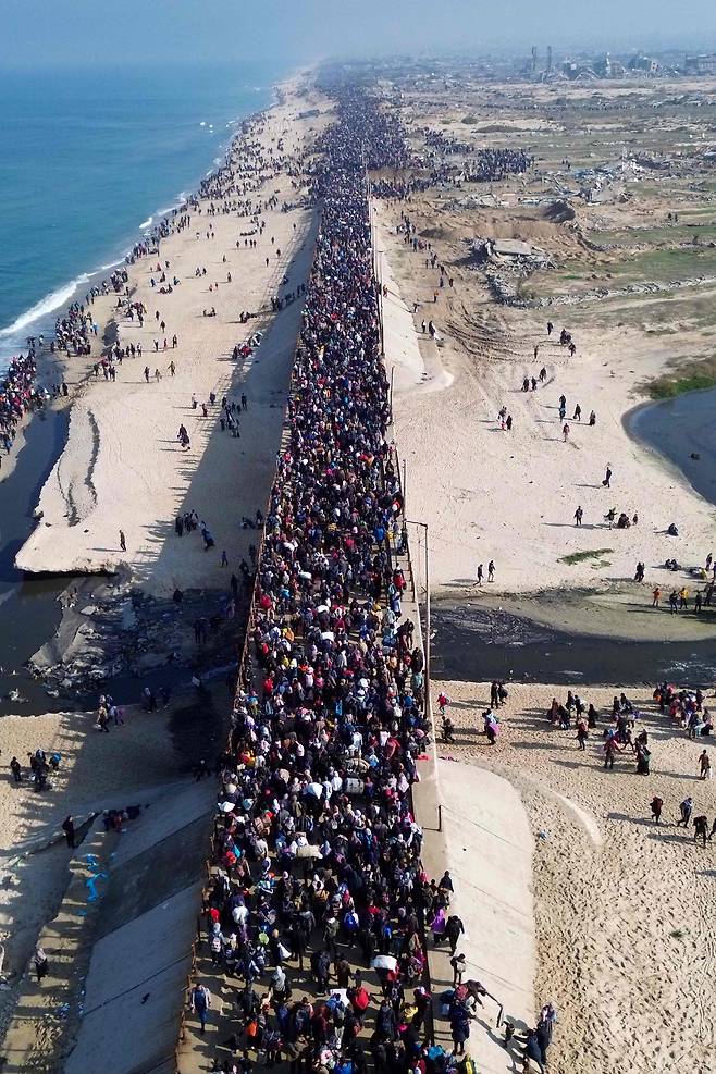 이스라엘과 하마스가 일시적인 휴전에 들어가자, 전쟁으로 인해 집을 떠났던 수많은 가자(Gaza) 난민들이 해안선을 따라서 가자 시티 쪽으로 걸어가고 있다./AFP 연합뉴스
