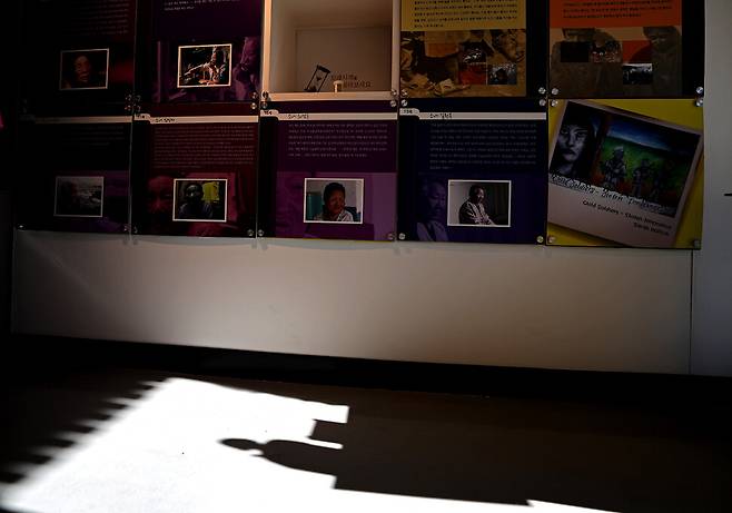 한낮 따사로운 햇살에 ‘평화의 소녀상’ 그림자가 바닥에 그려지고 있다. 뒤쪽으로 국내외 일본군 ‘위안부’ 피해자들의 이야기가 사진과 함께 걸려 있다.