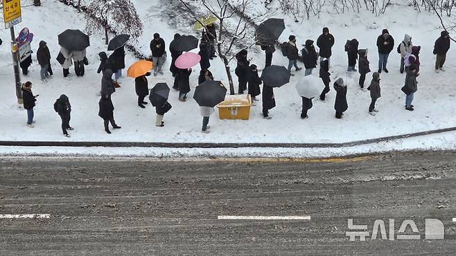 [수원=뉴시스] 김종택 기자 = 수도권 지역에 눈이 내린 7일 경기도 수원시 영통구 망포역 인근에서 출근길 시민들이 버스를 기다리고 있다. 2025.02.07. jtk@newsis.com