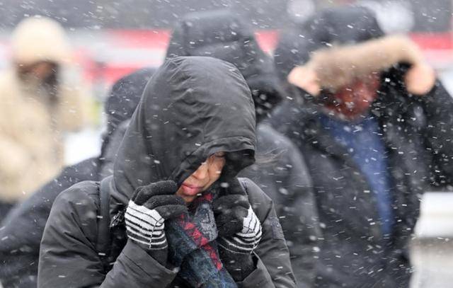 한파와 함께 전국 곳곳에 눈이 내린 7일 서울 종로구 광화문 사거리에서 시민들이 두꺼운 외투를 입고 얼굴을 가린 채 출근하고 있다. 홍인기 기자