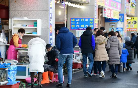 충남 홍성군 남당한에서 열린 새조개 축제장을 찾은 관광객이 식당 앞에서 수산물을 구경하고 있다. [사진 홍성군]