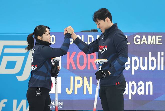 ▲ 8일 중국 하얼빈 핑팡 컬링 아레나에서 열린 컬링 믹스더블 결승 한국과 일본의 경기에 앞서 한국 김경애-성지훈이 손을 맞잡고 있다. ⓒ연합뉴스