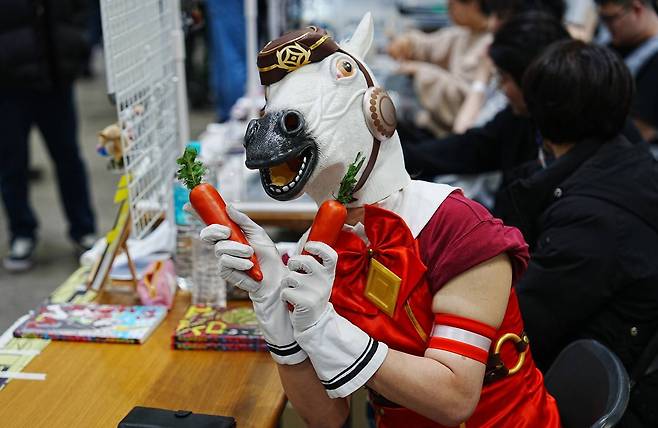 당근을 들고 말머리 가면을 쓴 판매자의 모습